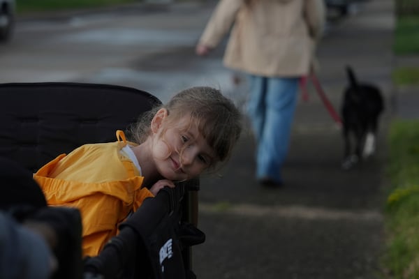 Eliza Ethridge, 5, rides in a wagon during a walk with her family, Thursday, April 10, 2025, in Evansville, Ind. (AP Photo/Joshua A. Bickel)