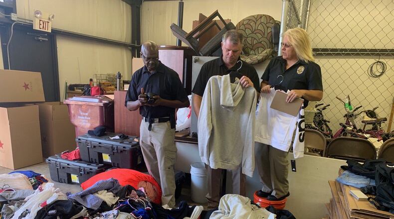 Covington police sort through piles of clothing reported stolen from Macy's department stores along the East Coast. The merchandise spilled onto I-20 last Friday after a police chase and wreck, authorities said.