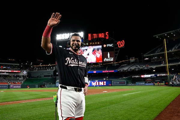 Washington Nationals' Keibert Ruiz waves to his parents while being interviewed after a baseball game against the Atlanta Braves in Washington, Thursday, May 22, 2025. (AP Photo/Terrance Williams)