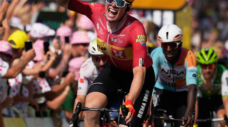Norway's Soren Waerenskjold celebrates as he crosses the finish line to win the eleventh stage of the Tour de France cycling race with start in Vichy and finish in Nevers, France, Wednesday, July 15, 2026. (AP Photo/Mosa'ab Elshamy)