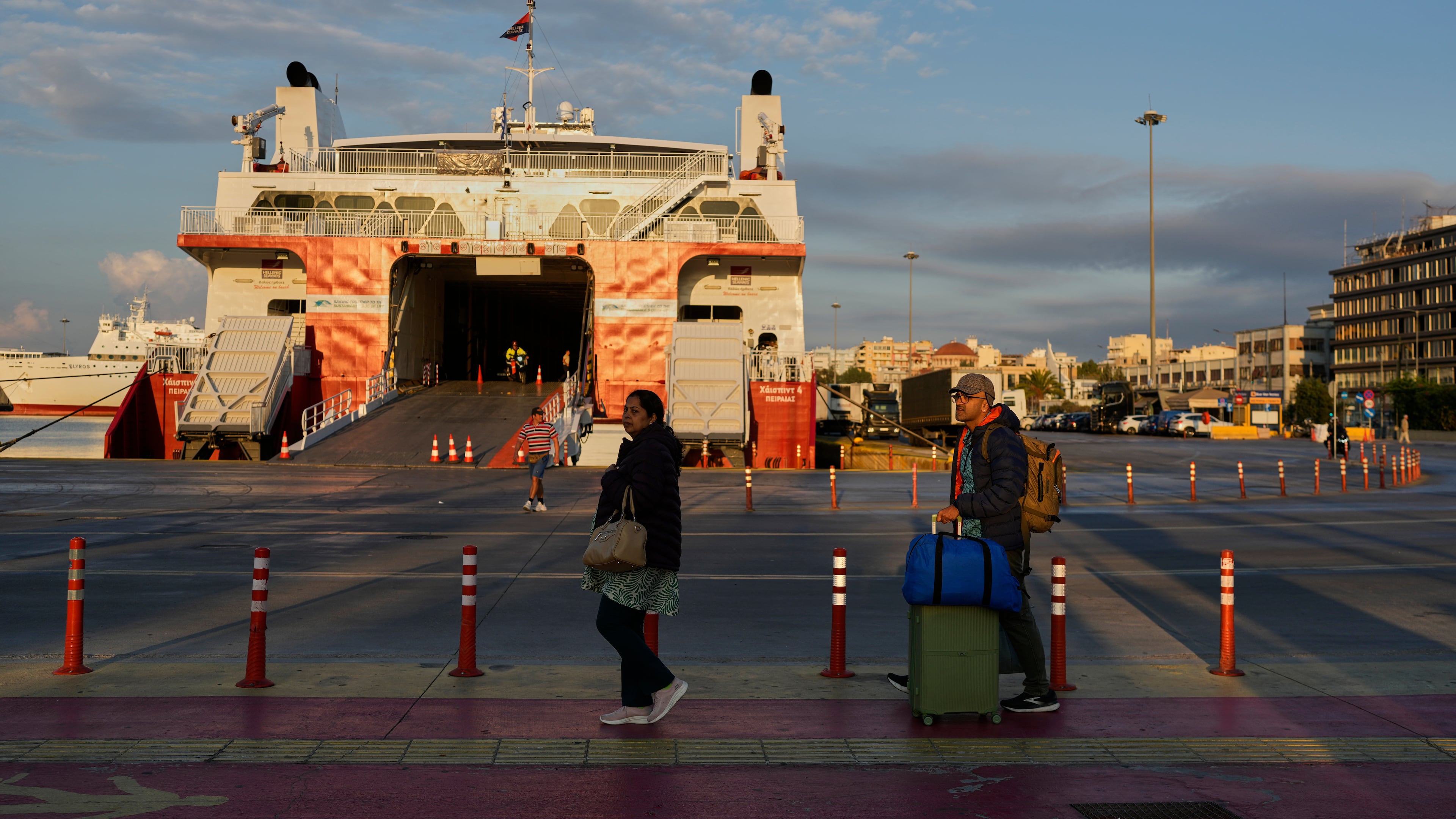 Passengers walk past a docked ferry in Piraeus port near Athens during a nationwide 24-hour strike, as labor unions demand higher wages and the withdrawal of a bill that changes work hours Wednesday, Oct. 1, 2025.(AP Photo/Petros Giannakouris)