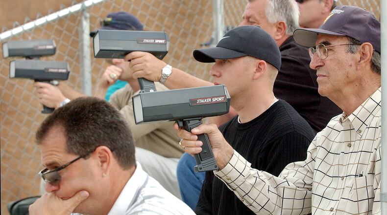 Pro scouts check pitch speeds at a Georgia high school game. (AJC file photo)