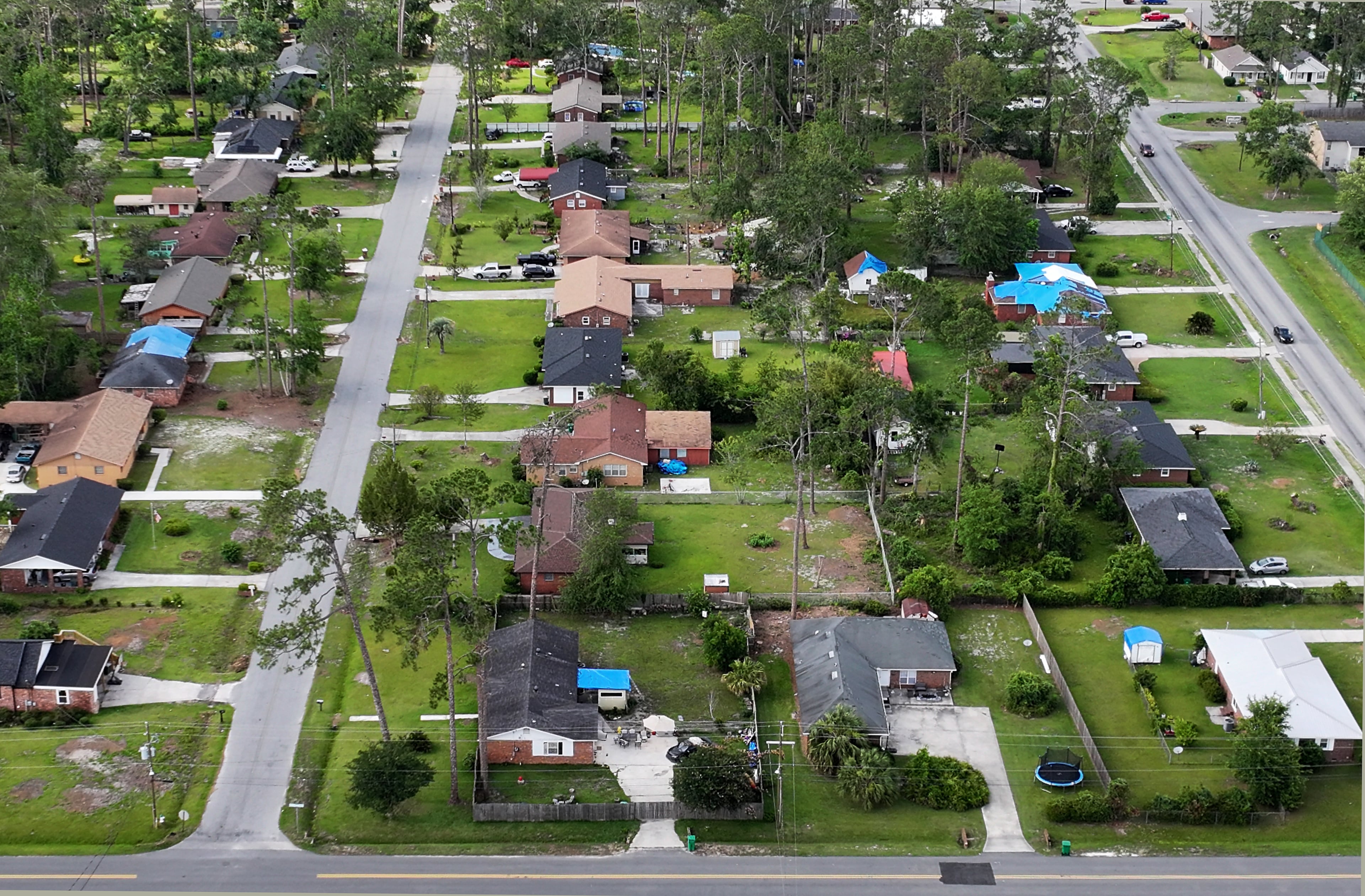 Many parts of Valdosta have been repaired, but blue tarps scattered across neighborhoods still cover the rooftops of hundreds of damaged homes and buildings mangled by the storm remain unrepaired. (Hyosub Shin/AJC)