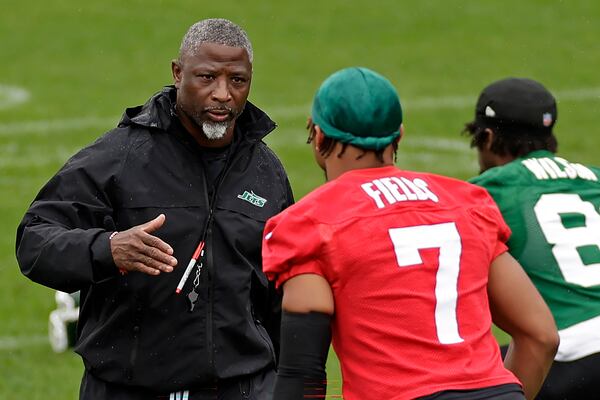 New York Jets head coach Aaron Glenn reaches to shake hands with Justin Fields during practice at NFL football minicamp, Tuesday, June 10, 2025, in Florham Park, N.J. (AP Photo/Adam Hunger)