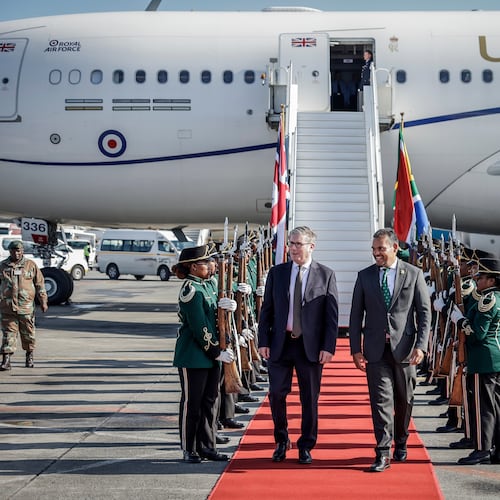 Britain's Prime Minister Keir Starmer, center left is welcomed by a South African representative upon his arrival at the OR Tambo International airport in Ekurhuleni on Friday, Nov. 21, 2025 ahead of the G20 leaders' Summit. ( Marco Longari /Pool Photo via AP)