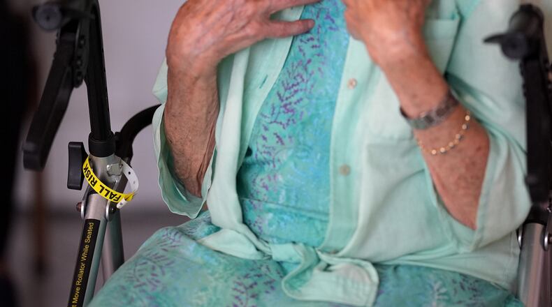 A "Fall Risk" alert bracelet marks the walker of Anna Fischbein as she speaks about the loss of a beloved Haitian home health care worker whose Temporary Protected Status expired this week, during an interview in her apartment, Thursday, July 30, 2026, in Sunny Isles Beach, Fla. (AP Photo/Rebecca Blackwell).