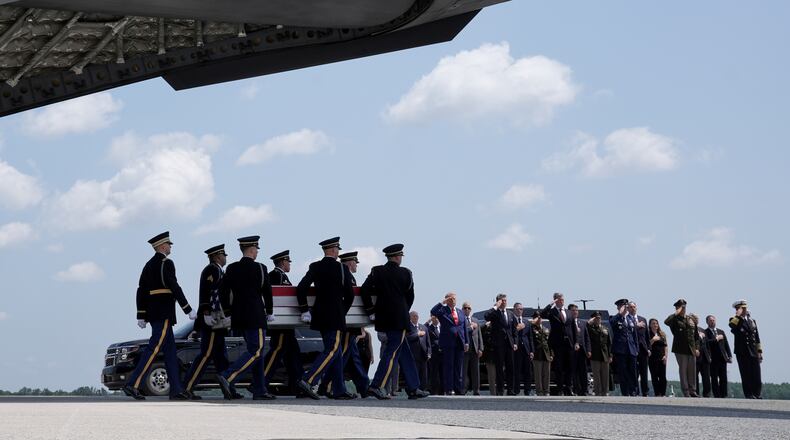 President Donald Trump and Secretary of Defense Pete Hegseth and others, salute as a U.S. Army carry team moves a transfer case containing the remains of Sgt. Angel S. Rampersad, of Ozone Park, N.Y. Wednesday, July 22, 2026, at Dover Air Force Base, Del. (AP Photo/Matt Rourke)