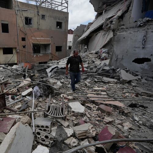 A man walks between destroyed buildings that were hit in Israeli airstrikes in Burj al-Shemali village near the southern port city of Tyre, Lebanon, Tuesday, May 26, 2026. (AP Photo/Mohammed Zaatari)