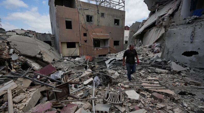A man walks between destroyed buildings that were hit in Israeli airstrikes in Burj al-Shemali village near the southern port city of Tyre, Lebanon, Tuesday, May 26, 2026. (AP Photo/Mohammed Zaatari)