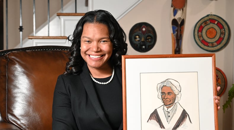 Sojourner Grimmett holds a drawing of Sojourner Truth that was drawn by her grandmother at her home, Thursday, Feb. 2, 2023, in Atlanta. Sojourner Grimmett was named after Sojourner Truth by her father, a noted scholar of black studies and biographer of Malcolm X. She says the name has had an impact on her life and her career. (Hyosub Shin / Hyosub.Shin@ajc.com)