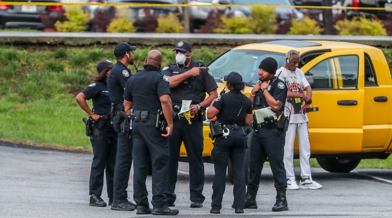 Atlanta police officers investigate a shooting after a gunman tried to steal an armored truck this week. (John Spink / John.Spink@ajc.com)