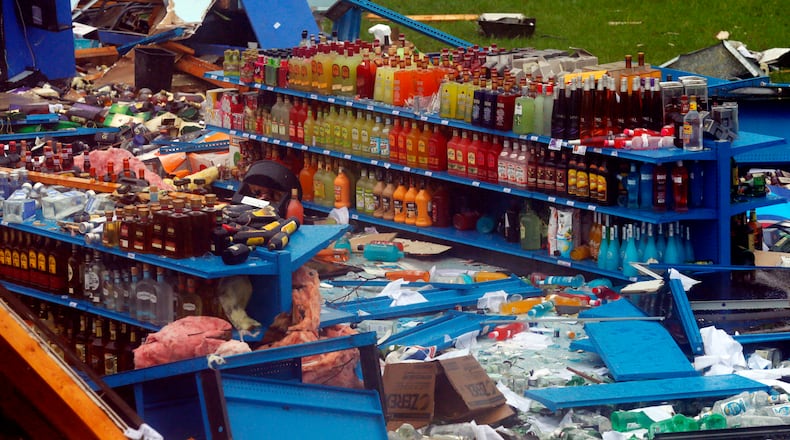 Liquor bottles remain untouched on a shelf after a possible tornado touched down destroying several businesses, Thursday, June 22, 2017, in Fairfield, Ala. (AP Photo/Butch Dill)