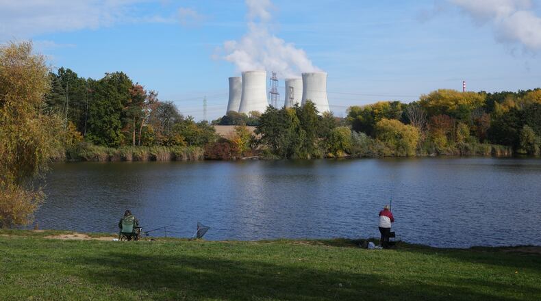 People fish near the towering Dukovany nuclear power plant, background, in Dukovany, Czech Republic, Oct. 21, 2025. (AP Photo/Petr David Josek)