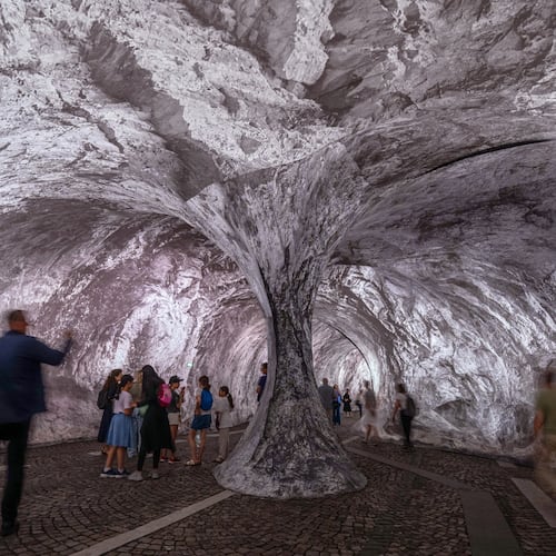 Visitors walk into the artwork "The Pont Neuf Cave" by French street artist JR on the Pont Neuf bridge, Tuesday, June 16, 2026, in Paris, open to the public from June 15 to 28. (AP Photo/Aurelien Morissard)