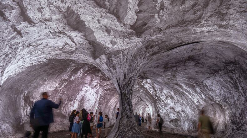 Visitors walk into the artwork "The Pont Neuf Cave" by French street artist JR on the Pont Neuf bridge, Tuesday, June 16, 2026, in Paris, open to the public from June 15 to 28. (AP Photo/Aurelien Morissard)