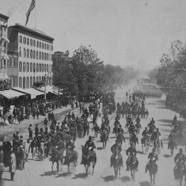 People watch soldiers on horseback followed by those on foot, parade down Pennsylvania Avenue in Washington, during the "Grand Review of the Armies" on May 23-24, 1865. (Matthew Brady/Library of Congress via AP)