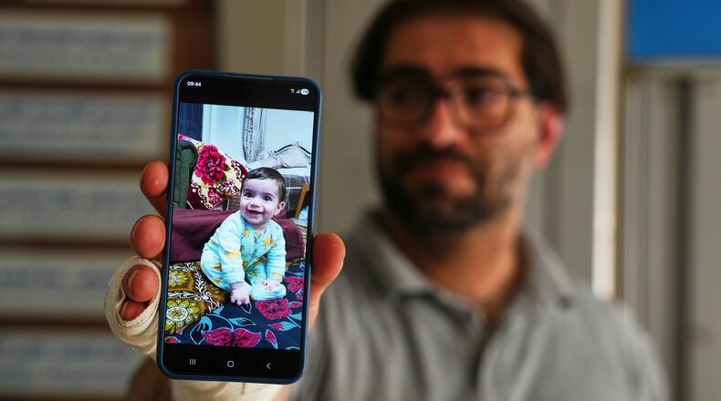 Fahd Abu Haikal, 41 displays a mobile photo of his seven month old Palestinian baby boy Sam, who was killed on Friday when Israeli soldiers fired at the vehicle carrying him and his parents, in Tel Rumeida, at a hospital in the West Bank city of Hebron Saturday, June 6, 2026. (AP Photo/Mahmoud Illean)