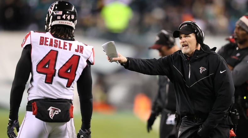 Falcons head coach Dan Quinn confers with Vic Beasley Jr. between defensive plays against the Eagles in their NFC Divisional Game on Saturday, Jan. 13, 2018, in Philadelphia. \