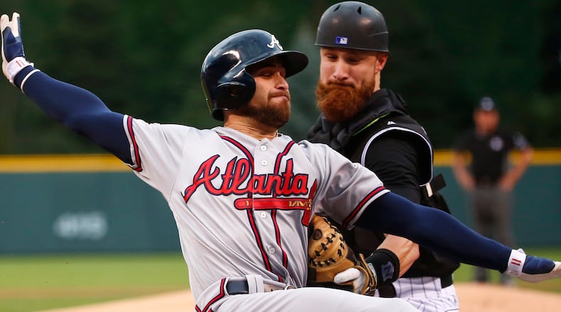 Ender Inciarte is tagged out at home plate by Colorado Rockies catcher Jonathan Lucroy during the first inning of Monday's game.