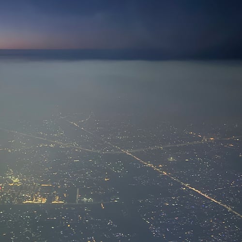 A layer of smog hangs over the skyline as seen from an aircraft window in New Delhi, India, Saturday, Oct. 25, 2025. (AP Photo/Yirmiyan Arthur)