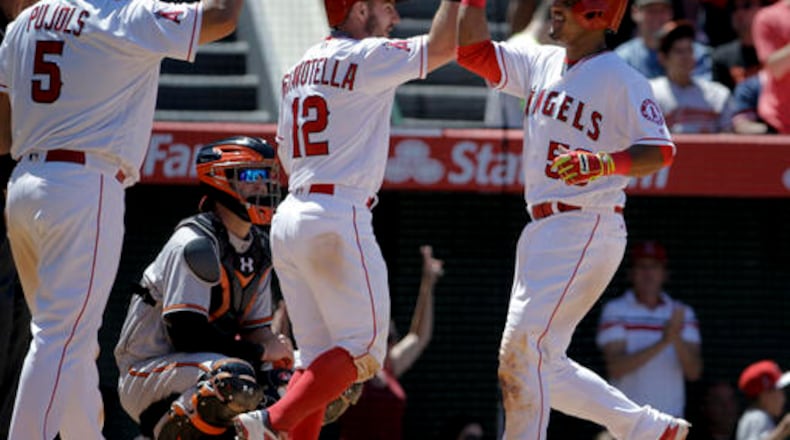 Los Angeles Angels' Carlos Perez, right, celebrates after hitting a three-run home run with Albert Pujols (5) and Johnny Giavotella (12) as Baltimore Orioles catcher Caleb Joseph looks on during the seventh inning of a baseball game in Anaheim, Calif., Sunday, May 22, 2016. (AP Photo/Chris Carlson)