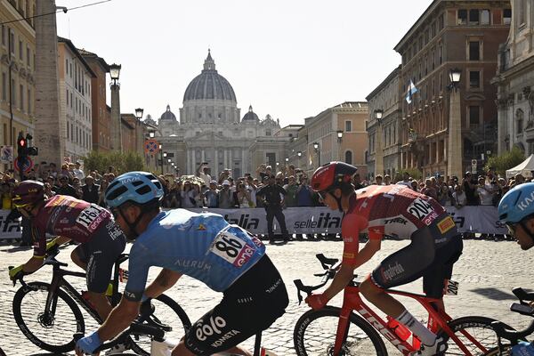 FILE - From left, Britain's Charles Quarterman, Italy's Francesco Gavazzi and Luxembourg's Alex Kirsch, backdropped by St. Peter's Basilica at the Vatican, compete during the last stage of the Giro d'Italia cycling race, in Rome, Sunday, May 28, 2023. (Fabio Ferrari/LaPresse via AP, File)