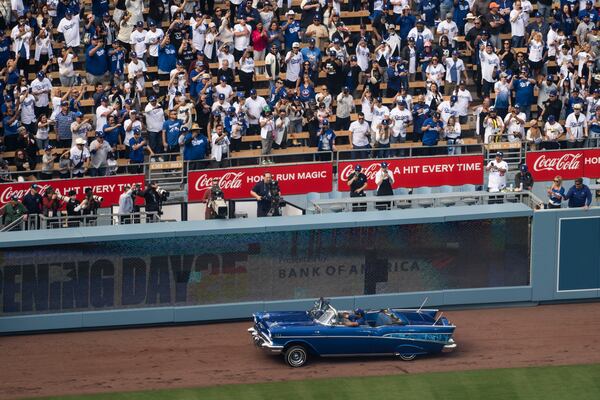 Ice Cube enters the field with the World Series trophy before the home-opening baseball game between the Los Angeles Dodgers and the Detroit Tigers in Los Angeles, Thursday, March 27, 2025. (AP Photo/Kyusung Gong)