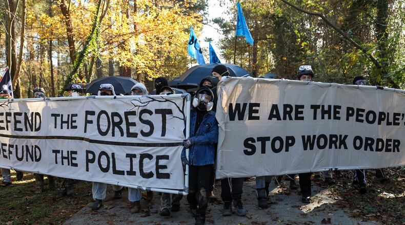 Protesters march against Atlanta's planned police and firefighter safety training center in an event organizers are calling a non-violent "Day of Action." (Riley Bunch / Riley.Bunch@ajc.com)