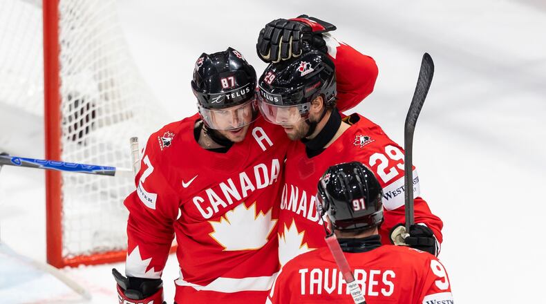 Canada's Parker Wotherspoon, center, celebrates his goal with Canada's Sidney Crosby, left, and Canada's John Tavares, right, during the 2026 IIHF Men's Ice Hockey World Championship preliminary round group B game between Canada and Denmark, in Fribourg, Switzerland, Monday, May 18, 2026. (Cyril Zingaro/Keystone via AP)