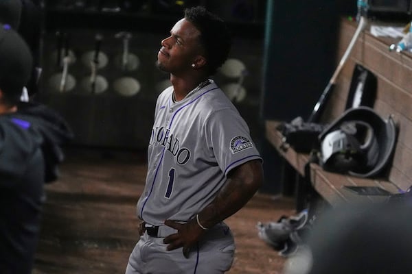 Colorado Rockies' Adael Amador stands in the dugout after lining out to Texas Rangers shortstop Josh Smith during the ninth inning of a baseball game Wednesday, May 14, 2025, in Arlington, Texas. (AP Photo/LM Otero)