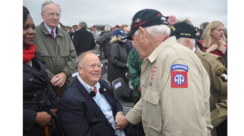 Former U.S. Senator Max Cleland, D-Ga., now secretary of the American Battle Monuments Commission, meets with D-Day veterans following a ceremony at Pointe-du-Hoc in Normandy, France, on June 5, 2014.