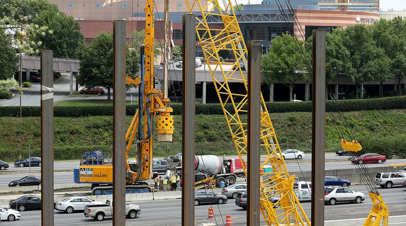 A crew works in the middle of I-285 in October 2016 where Cobb County started construction on a multi-use bridge over I-285 in the Cumberland Area across from the Cobb Galleria.