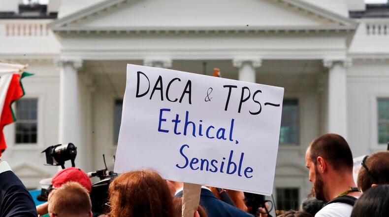 A person holds up a sign in support of the Deferred Action for Childhood Arrivals, known as DACA, and Temporary Protected Status programs during a rally in support of DACA and TPS outside of the White House, in Washington, Sept. 5, 2017. (AP Photo/Jacquelyn Martin, file)