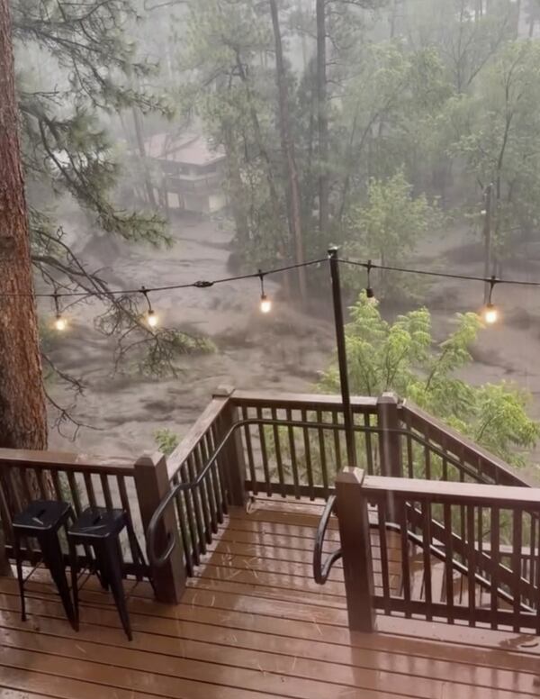 In this image taken from video, flash flooding is seen behind a house in Ruidoso, N.M., Tuesday, July 8, 2025. (Kaitlyn Carpenter via AP)