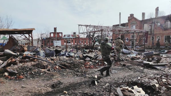 In this photo taken from video distributed by Russian Defense Ministry Press Service on Thursday, March 13, 2025, Russian soldiers walk between ruins of Sudzha, the biggest town in the Kursk region of Russia after it was taken over by Russian troops. (Russian Defense Ministry Press Service via AP)