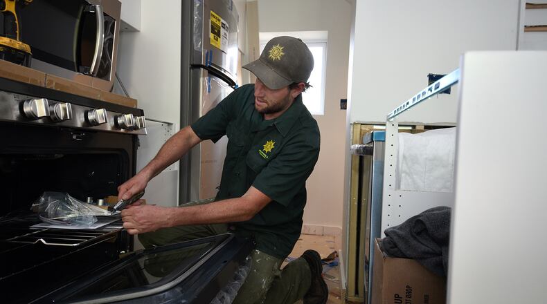 Andre Stone, COO of Renewable Rowhomes, unpacks a new gas stove that he will install in a tiny house his company is rehabbing in the Pigtown neighborhood on April 20, 2017 in Balitmore, Md. (Barbara Haddock Taylor/Baltimore Sun/TNS)