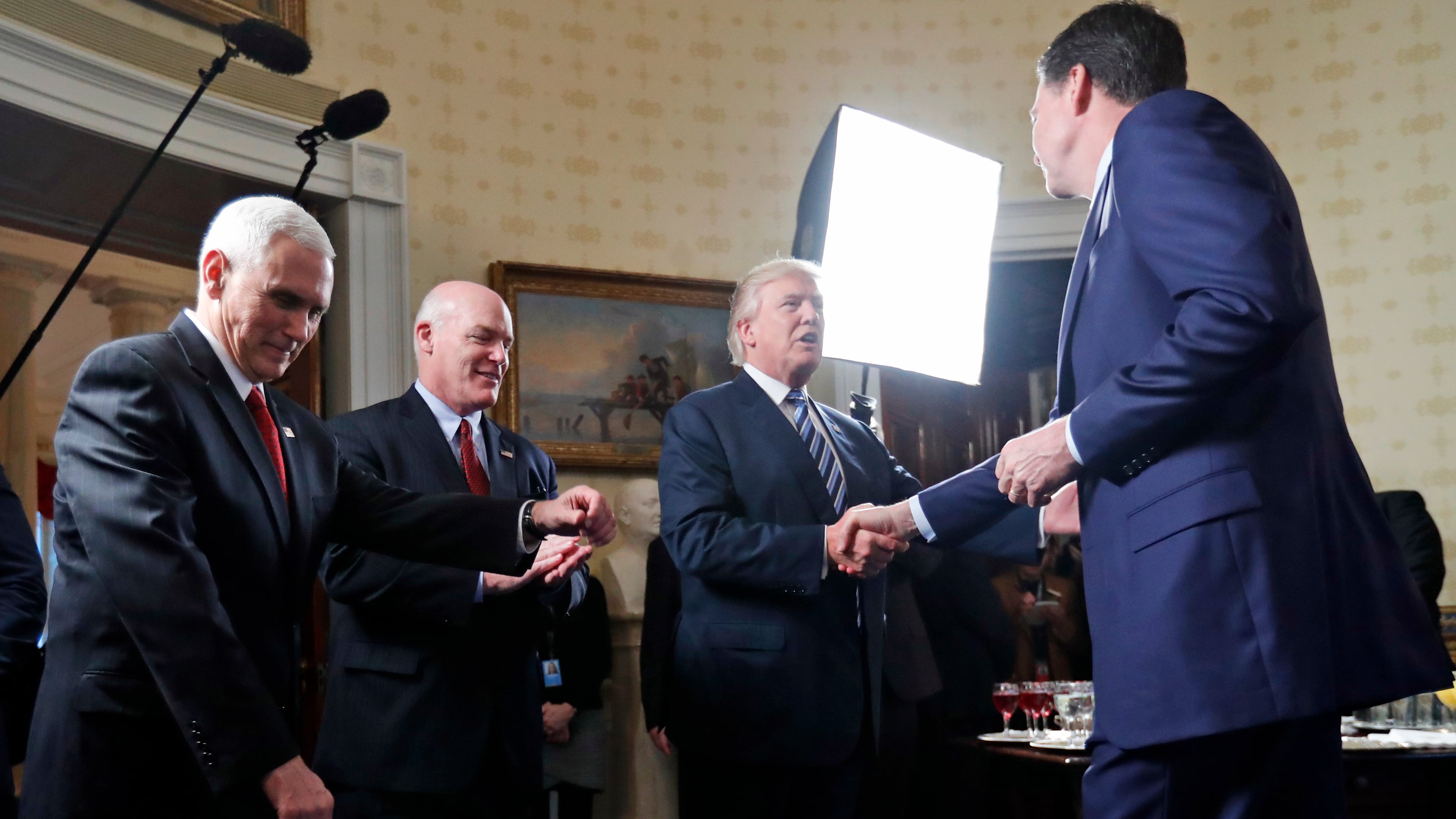 FILE - Vice President Mike Pence, left, and Secret Service Director Joseph Clancy stand as President Donald Trump shakes hands with FBI Director James Comey during a reception for inaugural law enforcement officers and first responders in the Blue Room of the White House, Jan. 22, 2017 in Washington. (AP Photo/Alex Brandon, File)