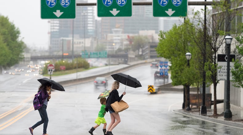 Pedestrians brave the rain in Atlanta, Georgia, on Monday, April 3, 2017. Scientists say bursts of rainfall could increase in frequency in coming years as a result of climate change. (DAVID BARNES / DAVID.BARNES@AJC.COM) AJC FILE PHOTO