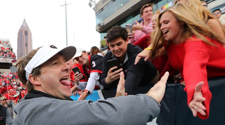 Georgia football head coach Kirby Smart high fives fans after beating Georgia Tech 38-7 in Atlanta. Will fans of UGA and other universities be less willing to buy season tickets if a juicy tax deduction is eliminated? Curtis Compton/ccompton@ajc.com