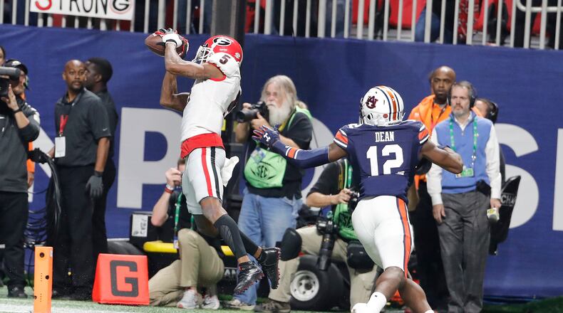Georgia wide receiver Terry Godwin (5) makes a touchdown catch against Auburn defensive back Jamel Dean (12) during the second half of the Southeastern Conference championship NCAA college football game, Saturday, Dec. 2, 2017, in Atlanta. (AP Photo/David Goldman)