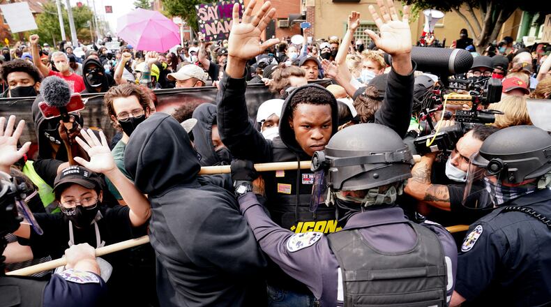FILE - Police and protesters converge during a demonstration, Wednesday, Sept. 23, 2020, in Louisville, Ky. Recent revelations about the search warrant that led to Breonna Taylor's death have reopened old wounds in Louisville's Black community and disrupted the city's efforts to restore trust in the police department. (AP Photo/John Minchillo, File)