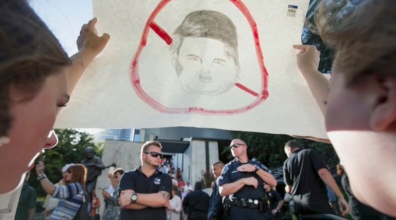 Protesters hold up a sign as security makes a walking path for attendees of an appearance where Republican presidential candidate Donald Trump spoke in Austin, Texas, Tuesday, Aug. 23, 2016. (Deborah Cannon/Austin American-Statesman via AP)