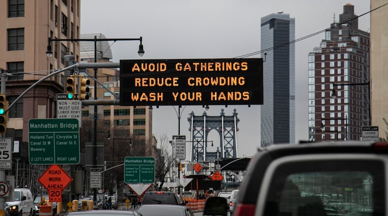 In this March 19, photo, a flashing sign urges New Yorkers to avoid gatherings, reduce crowding and to wash hands.  A South Georgia teacher fears that message has not yet been taken seriously in her community, and that puts her husband at risk due to pre-existing health conditions.