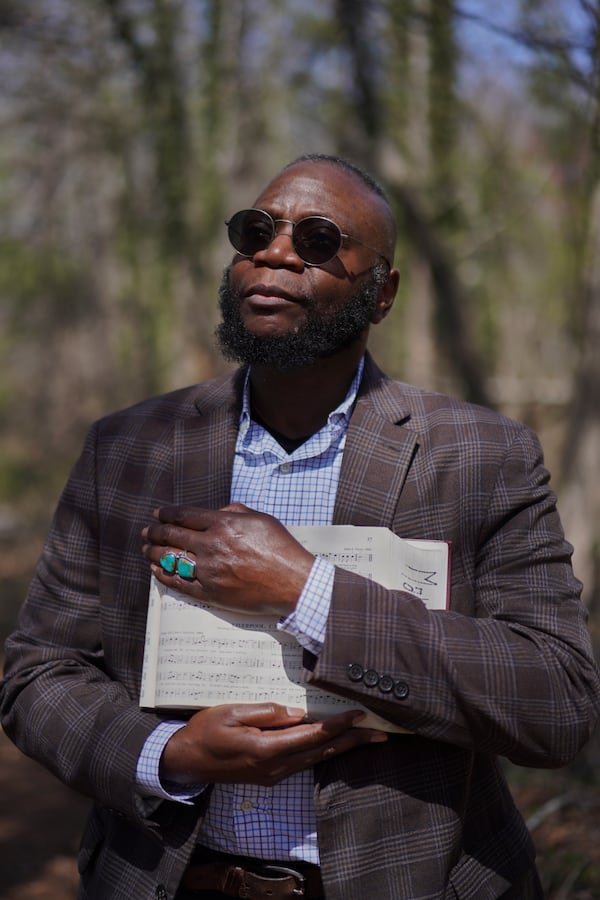 Bridge Hill Kennedy, poses for a portrait with his copy of "The Sacred Harp" songbook opened to the favorite song of his late nephew, at Holly Springs Primitive Baptist Church in Bremen, Ga., on Sunday, March 23, 2025. (AP Photo/Jessie Wardarski)