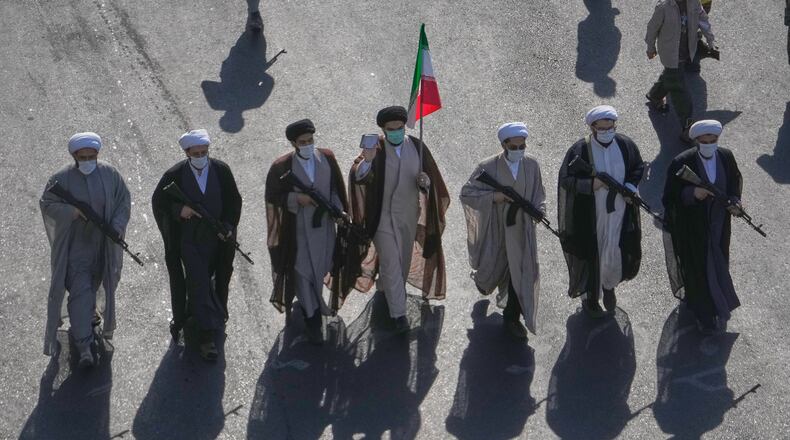 Shiite clerics carrying rifles march during the state-organized "Janfada," or "Sacrifice for Iran," military-style parade at Revolution Square in Tehran, Iran, Friday, Sept. 18, 2026. (AP Photo/Vahid Salemi)