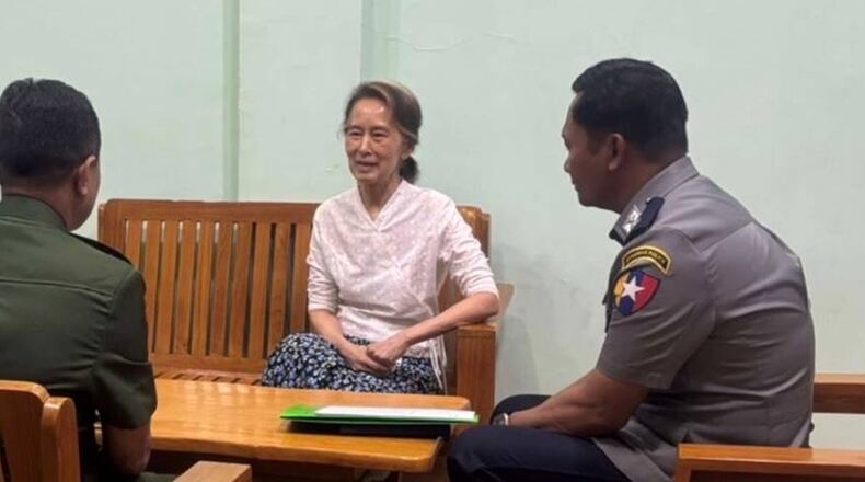 In this updated photo provided on April 30, 2026, by Myanmar Military True News Information Team, Myanmar's former leader Aung San Suu Kyi, center, talks with officials, in undisclosed location in Myanmar. (Myanmar Military True News Information Team via AP)