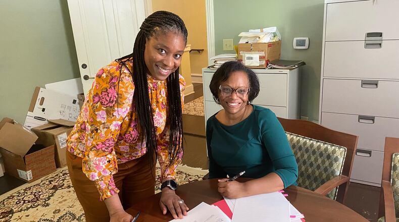 Shawanna Qawiy (left) and Mayor Beverly Burks (right) sign the contract that made Qawiy the city manager of Clarkston.