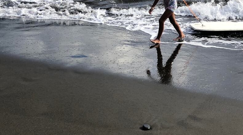 "I caught this young girl coming out of the water with her surf board onto the fine black sand beach in Tahiti," wrote Doris Goldstein.