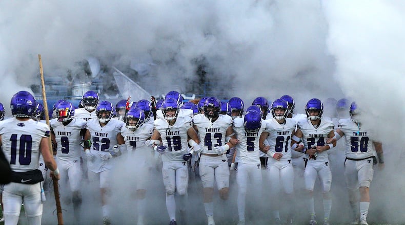 120921 Atlanta: Trinity Christian players take the field arm in arm to challenge the defending champions Prince Avenue Christian in their GHSA Class A Private Championship game on Thursday, Dec 9, 2021, in Atlanta. “Curtis Compton / Curtis.Compton@ajc.com”`