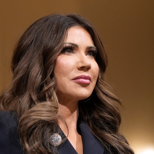 Homeland Security Secretary Kristi Noem raise her arm before the House Committee on Homeland Security on Capitol Hill in Washington, Thursday, Dec. 11, 2025. (AP Photo/Mark Schiefelbein)